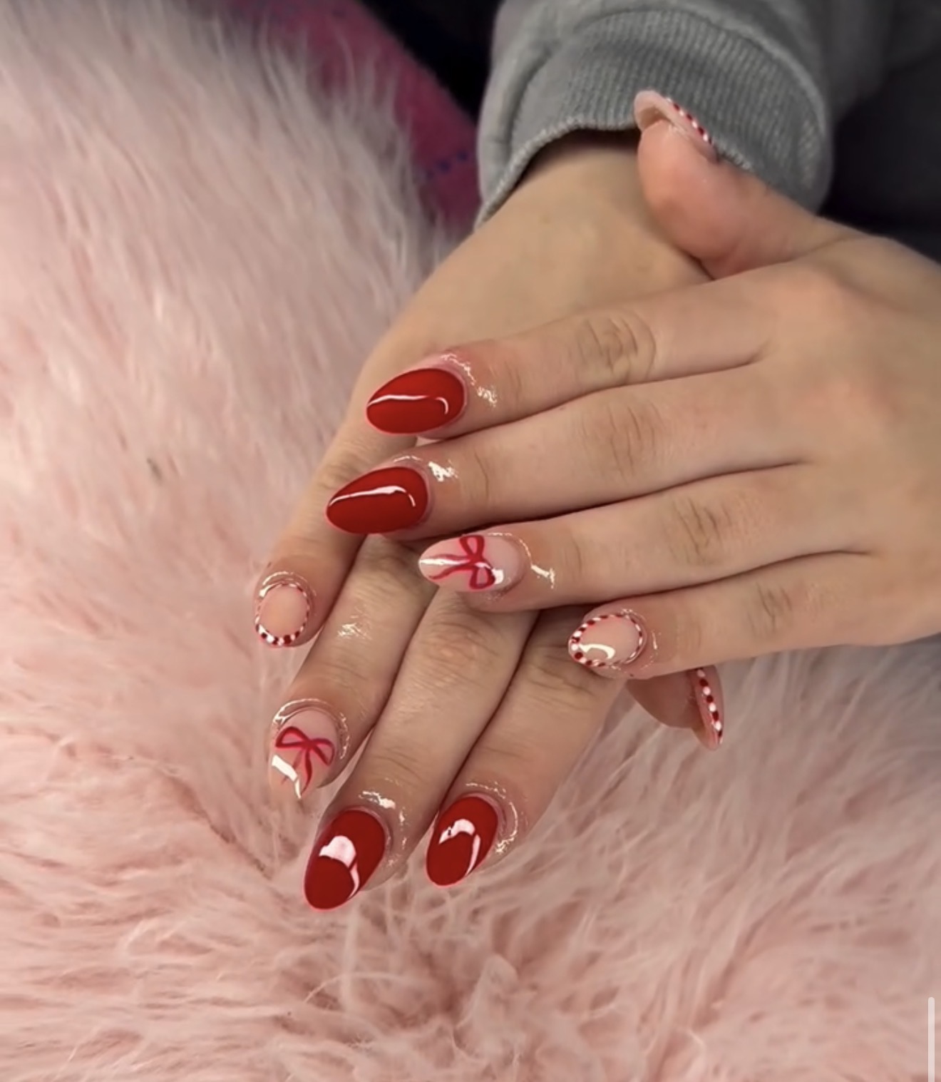 Red oval nails with hearts, bows and candy cane accents